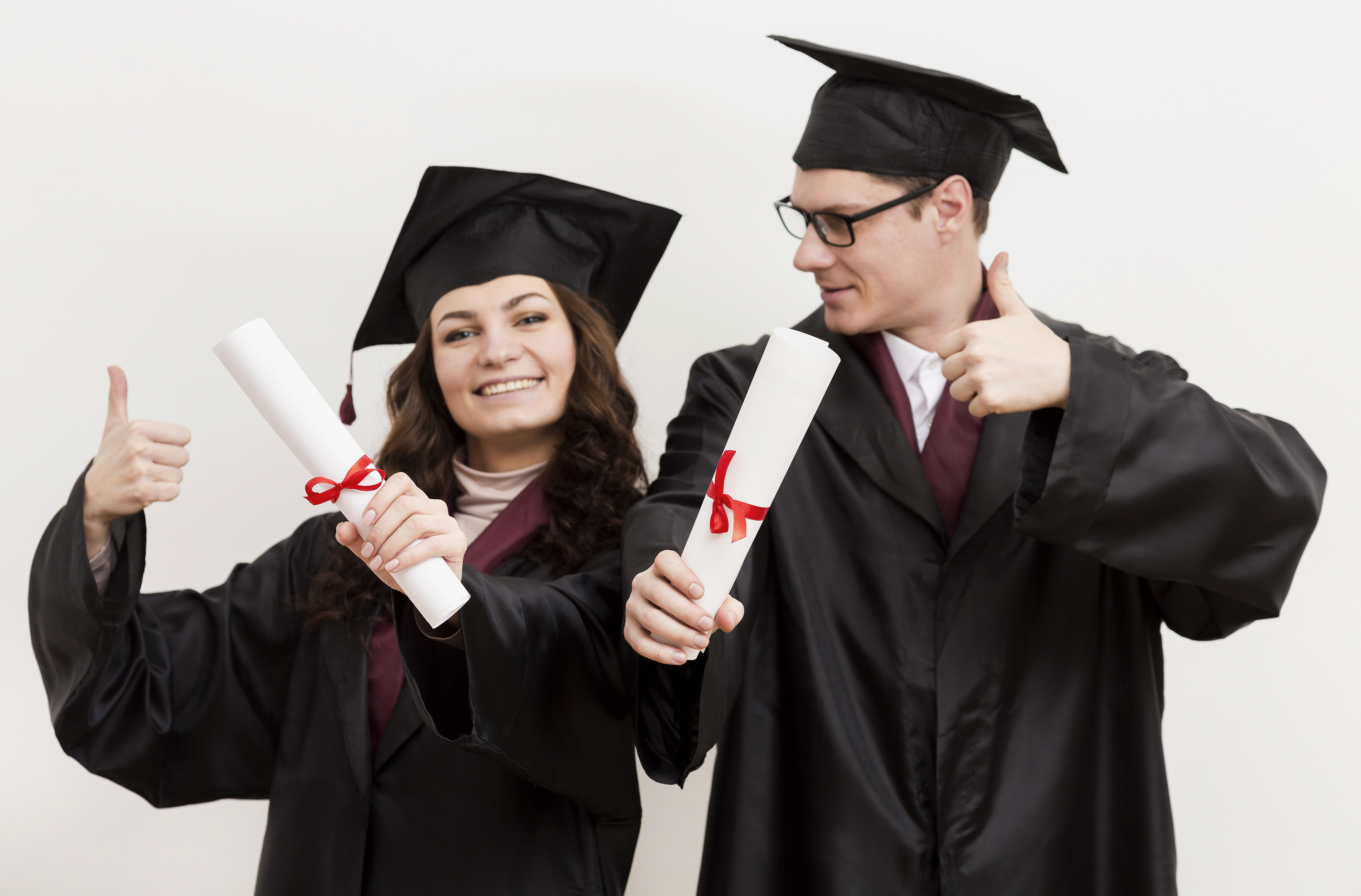 Estudiantes graduados celebrando con birretes